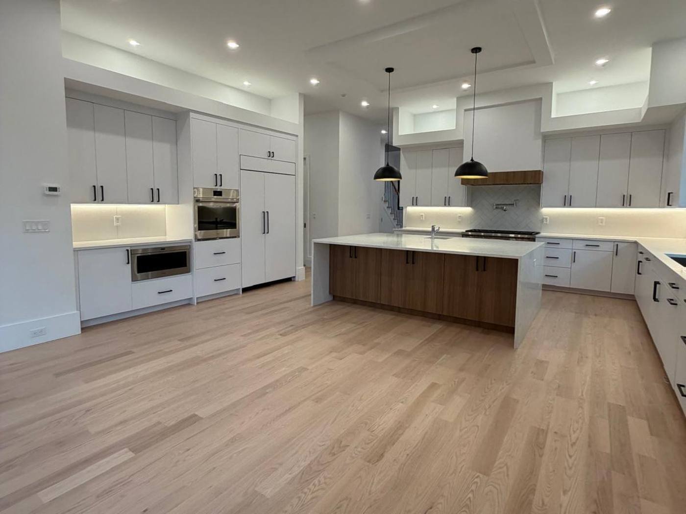 Spotless new-construction kitchen with white cabinets and oak floors in Westchester County